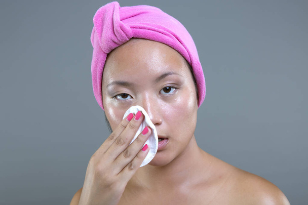 young asian ethnicity woman cleaning her face - Photo, Image