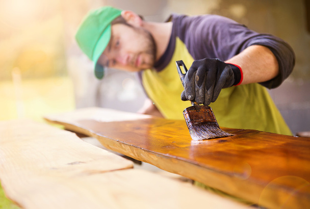 Handyman varnishing pine wooden planks - Photo, Image
