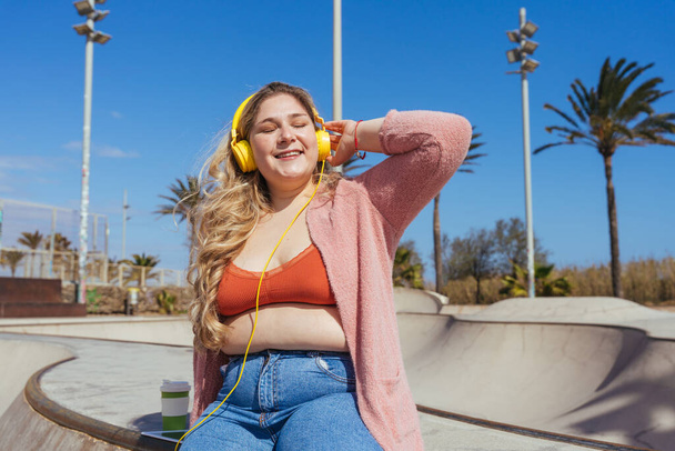Beautiful and cheerful plus size young woman outdoors - Pretty overweight curvy female, concepts about femininity, women power, female emancipation, body positivity and body acceptance - Фото, изображение