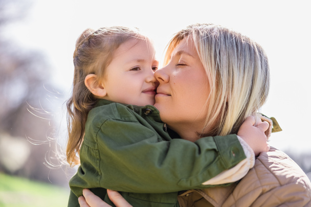 happy mom and daughter embracing outdoors - Photo, Image