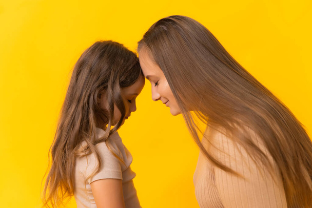 Family portrait of mother and daughter touching each others foreheads - Photo, Image