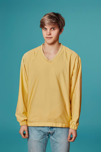 young handsome guy in yellow sweater posing - Фото, изображение