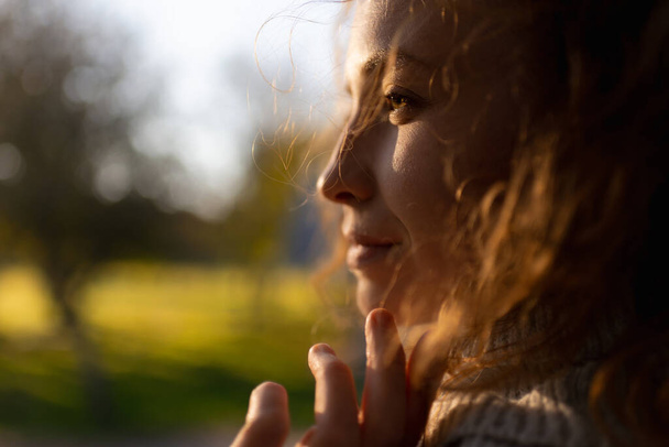 A young redhead woman is enjoying a relaxing moment with a blissful smile - Fotoğraf, Görsel