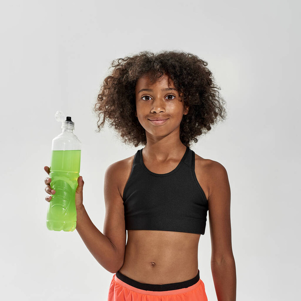 Black girl with sport drink looking at camera - Фото, зображення