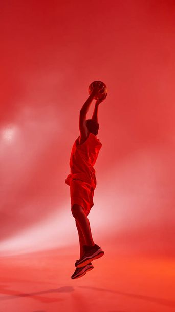 Black boy jumping and throwing basketball ball - Фото, изображение