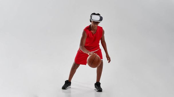 Black boy wearing VR glasses dribbling with ball - Fotó, kép