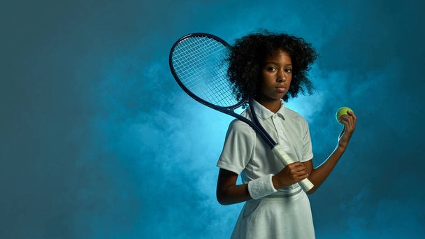 Girl tennis player hold ball with racket in studio - Foto, imagen