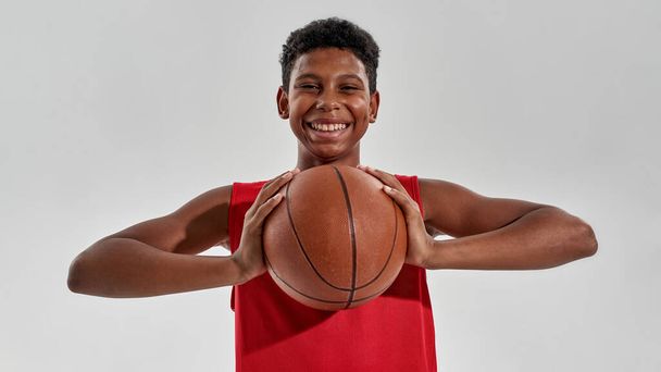Smiling black boy basketball player holding ball - Foto, Imagem