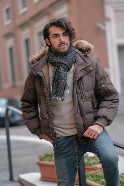 handsome Italian dark-haired guy with beard in city center with jacket. High quality photo - Foto, Imagem