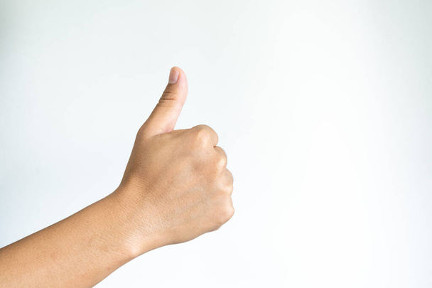 Closeup of asian male right hand showing thumbs up sign against white background - Fotografie, Obrázek