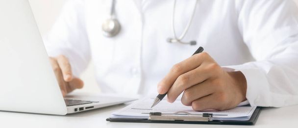 o médico analisa o relatório médico Exame físico completo, registro de dados do paciente com computadores portáteis. - Foto, Imagem