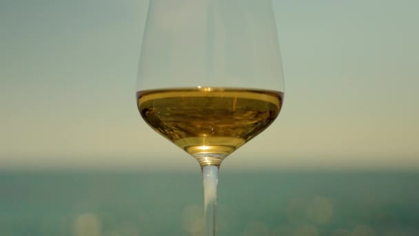 Bílé víno ve skle proti moři - Záběry, video