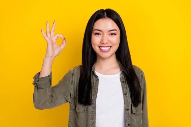 Portrait of good mood beaming lady show okay symbol promote shopping season isolated on yellow color background - Foto, afbeelding