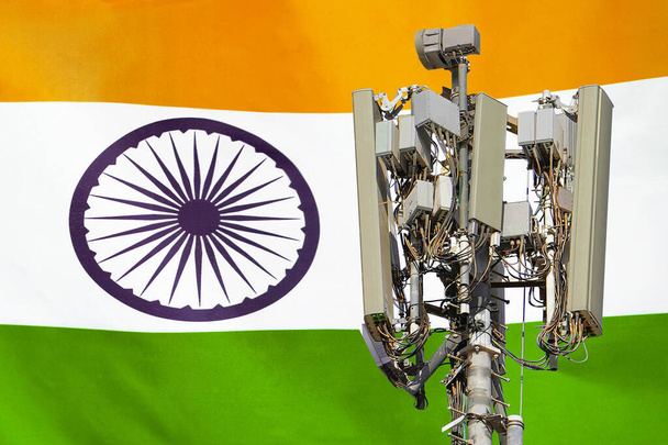 Telecommunications tower with a 5G cellular network antenna agains flag of India. Telecommunication tower of 5G cellular communication. 5G technology usage on telecommunications towers in India - Foto, Imagem