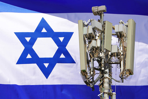 Torre de telecomunicações com uma antena de rede celular 5G agains bandeira de Israel. Torre de telecomunicações de comunicação celular 5G. Utilização da tecnologia 5G em torres de telecomunicações em Israel - Foto, Imagem