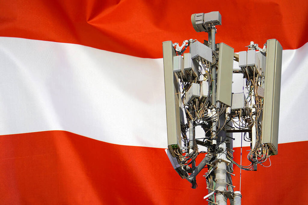 Torre de telecomunicações com uma antena de rede celular 5G agains bandeira da Áustria. Torre de telecomunicações de comunicação celular 5G. Utilização da tecnologia 5G em torres de telecomunicações na Áustria - Foto, Imagem