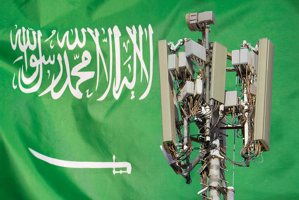 Torre de telecomunicações com uma antena de rede celular 5G agains bandeira da Arábia Saudita. Uso de tecnologia 5G em torres de telecomunicações na Arábia Saudita - Foto, Imagem