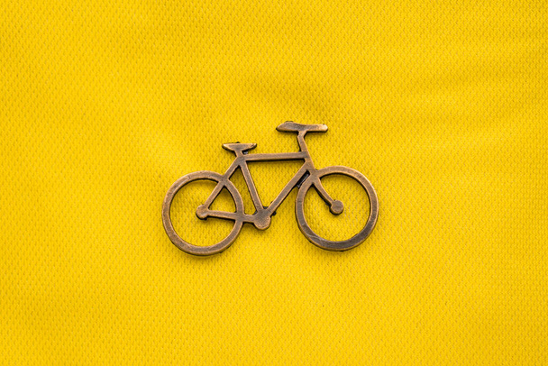 Golden bike pin on some colorful tour de france t-shirts - Foto, imagen