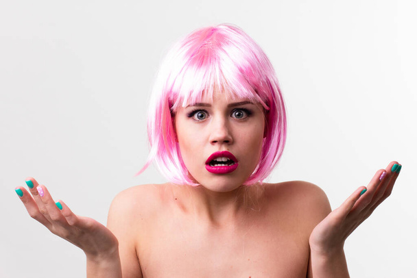 Rostro de una joven con maquillaje brillante sobre un fondo rosa con el pelo recogido en una cola de caballo lisa. - Foto, imagen