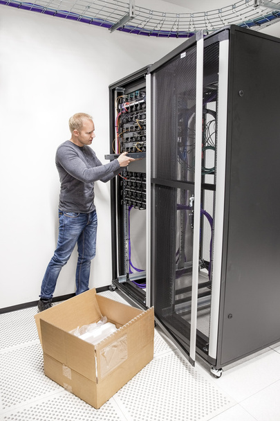 Ingénieur informatique installe un commutateur réseau dans le datacenter
 - Photo, image