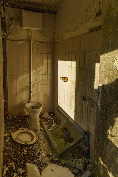 Dark room with broken toilet in industrial lost place complex - Foto, Bild