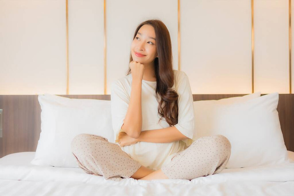 Portrét krásný mladý asijské žena úsměv relax volný čas na posteli v ložnici interiér - Fotografie, Obrázek