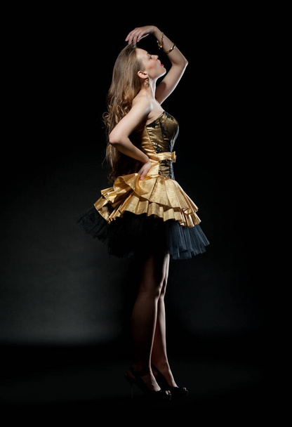 Beautiful sexy brunette girl posing on a black background in an evening dress - Foto, Imagen