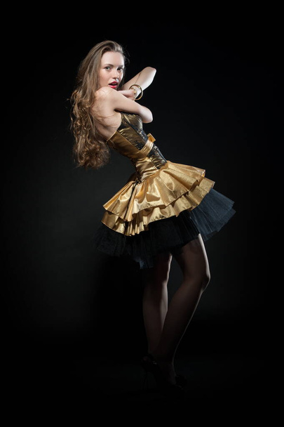 Beautiful sexy brunette girl posing on a black background in an evening dress - Foto, Imagen