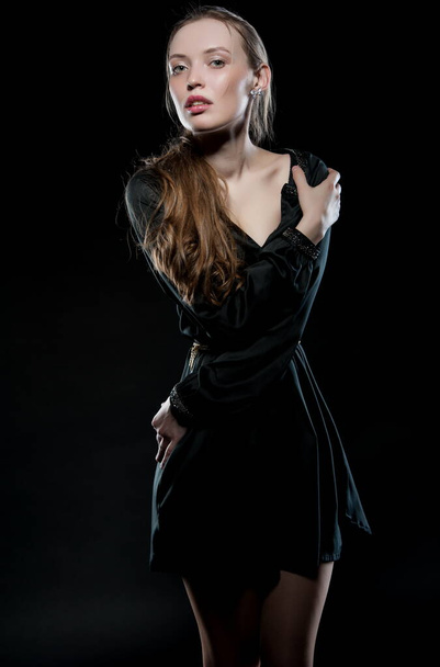 Beautiful sexy brunette girl posing on a black background in an evening dress - Fotografie, Obrázek