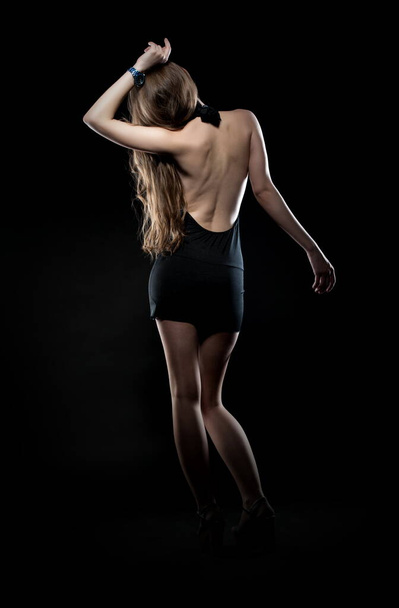 Beautiful sexy brunette girl posing on a black background in an evening dress - Foto, afbeelding