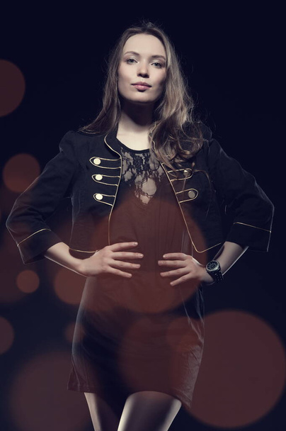 Beautiful sexy brunette girl posing on a black background in an evening dress - Foto, imagen