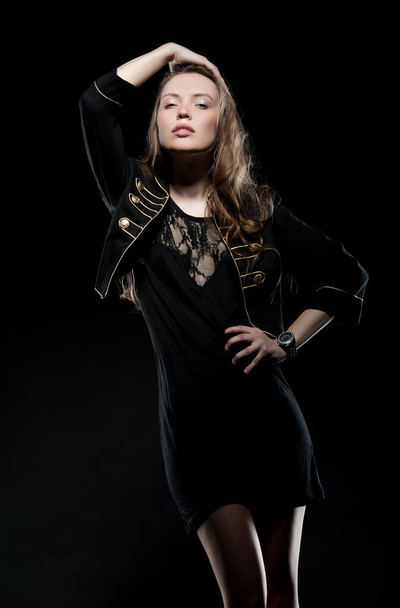 Beautiful sexy brunette girl posing on a black background in an evening dress - Фото, зображення
