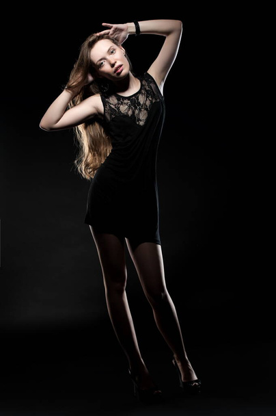 Beautiful sexy brunette girl posing on a black background in an evening dress - Zdjęcie, obraz