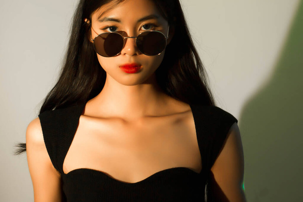 Concept de mode et de beauté, Portrait de femme de mode avec un maquillage éclatant et portant des lunettes de soleil. - Photo, image