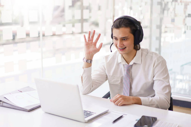 Business concept, Businessman greeting with colleague by headset and microphone on video conference. - Фото, изображение