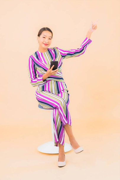 Muotokuva kaunis nuori aasialainen nainen käyttää älypuhelimella väri eristetty tausta - Valokuva, kuva