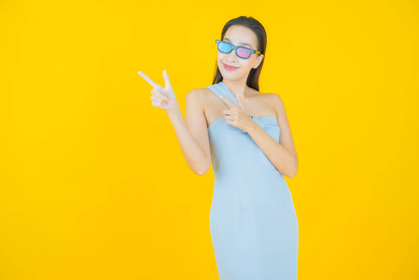 Retrato hermosa joven mujer asiática usar gafas 3D en el fondo de color - Foto, imagen