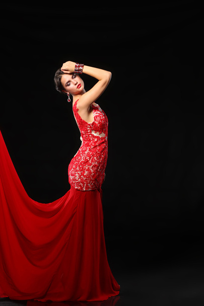 Young beauty woman in red dress. Isolated on black background - Фото, изображение