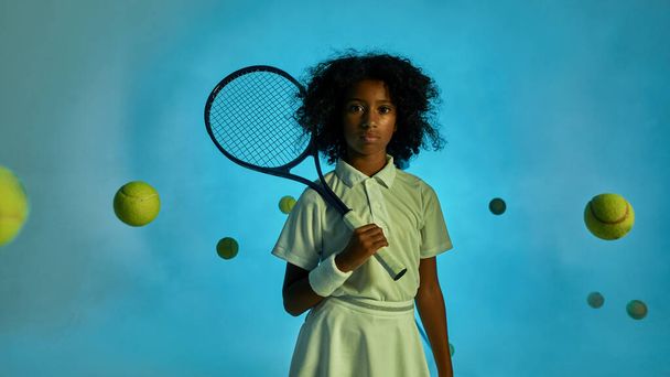 Tennis balls fly around confident girl player - Fotó, kép