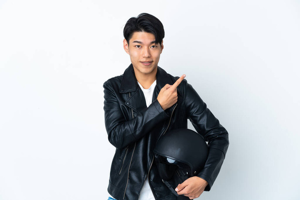 Chinese man with a motorcycle helmet isolated on white background pointing to the side to present a product - Φωτογραφία, εικόνα