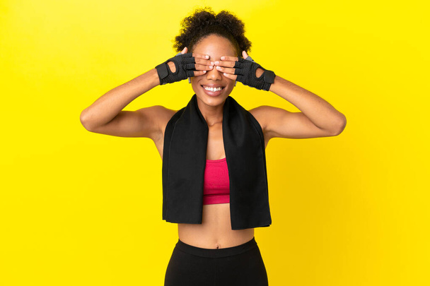 Young African sport woman isolated on yellow background covering eyes by hands - Photo, Image