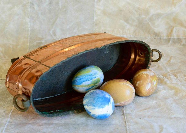 ancient copper bowl with colored eggs, celebration of Easter, still life - Foto, Imagem