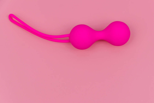 Ben Wa balls or Geisha balls on pink background. Pink double vaginal balls - Foto, afbeelding