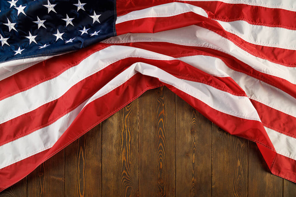 bandera de EE.UU. arrugada sobre fondo plano de superficie de madera texturizada - Foto, Imagen