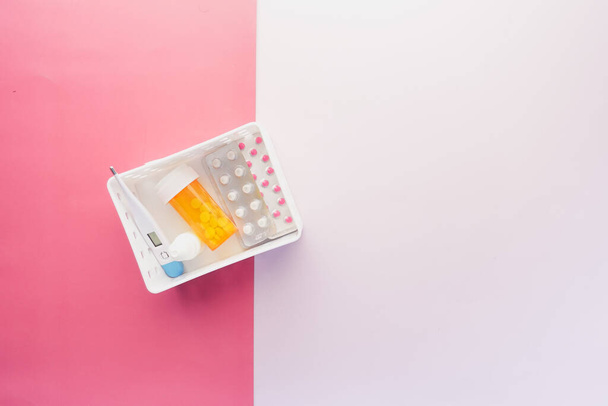 медицинский контейнер для таблеток, блистерная упаковка и термометр в пластиковом органайзере  - Фото, изображение