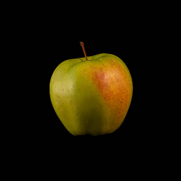 ein gelber Apfel auf schwarzem Hintergrund, ideal für Tapeten - Foto, Bild