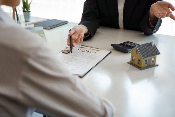 Agente di intermediazione immobiliare che presenta e consulta il cliente al processo decisionale firmare accordo modulo di assicurazione. - Foto, immagini