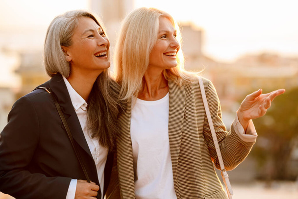Mature multiracial businesswomen smiling and talking during meeting outdoors - Foto, Imagem
