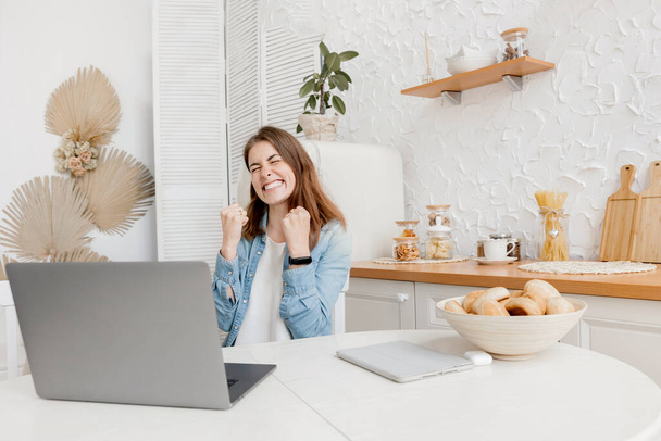 happy young woman with laptop in kitchen - Zdjęcie, obraz