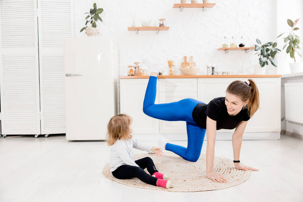 mother and daughter doing yoga exercises at home - Φωτογραφία, εικόνα